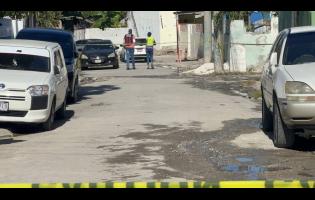 A police investigator and an investigator from the Independent Commission of Investigations (INDECOM) at the scene of a fatal police shooting in the Waltham area of St Andrew on April 15, 2026.