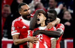 Bayern’s Luis Diaz (centre) celebrates with Dayot Upamecano (right) and Jonathan Tah after scoring their third goal during the Champions League quarterfinal second leg soccer match against Real Madrid in Munich, Germany, on Wednesday. Bayern won 4-3.