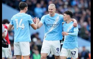 Manchester City’s Erling Haaland (centre) celebrates with his teammates Nico Gonzalez and Phil Foden at the end of the English Premier League match between Manchester City and and Arsenal, in Manchester, England, yesterday.