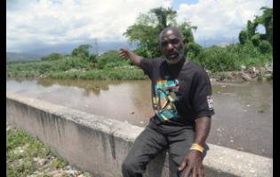 Christopher Irvin sits at the edge of Sandy Gully in St Andrew, where he has spent two decades risking his life in crocodile-infested waters to rescue victims and recover bodies. 