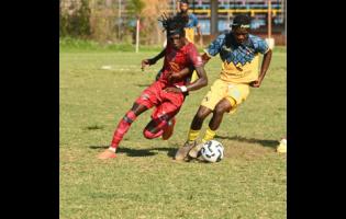 Montego Bay United’s Deonjay Brown (left) and Racing United’s Nickyle Ellis battle for the ball during their Jamaica Premier League game at Jarrett Park in Montego Bay yesterday. Montego Bay won 4-1.