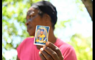 Peaches Sutherland, grandmother of Kland Doyle, who died on Monday following an altercation with his peers, holds a photo of him at their home in Castle Hill, Bath, St Thomas.