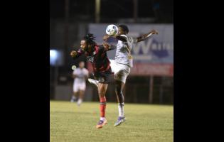 Shane Watson (left) of Arnett Gardens F.C. and James Gallimore of Cavaliers S.C. compete for the ball during their Jamaica Premier League football match at the Anthony Spaulding Sports Complex on Thursday.