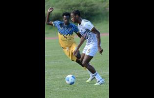 Rudolph Brown/Photographer 
Chavany Shaun Willis (left) of Racing United and Akil Kyel Henry of Cavalier challenge for the ball during the Jamaica Premier League football match at Stadium East on Sunday.