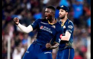 Gujarat Titans’ Jason Holder (left) celebrates the wicket of Royal Challengers Bengaluru’s Jitesh Sharma during the Indian Premier League cricket match in Ahmedabad, India, on Thursday.