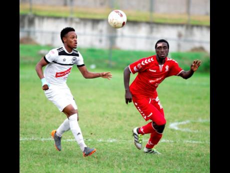 Cavalier FC's Alex Marshall (left) keeps his eyes on the ball while  UWI FC's Michael Heaven does his best to stay close to the attacker, in their Red Stripe Premier League encounter at the UWI Mona Bowl on Sunday, December 2, 2019.