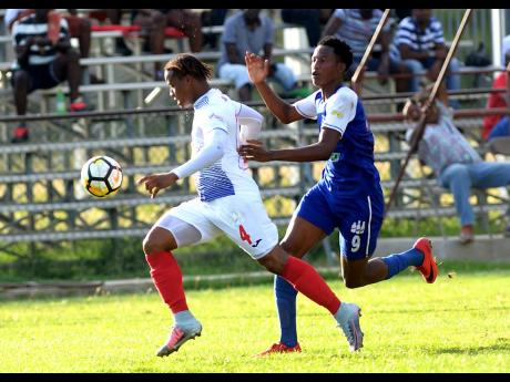 Shorn Hector
Portmore’s Roshane Sharpe (left) strides forward while being chased by Reno defender Kirk-Patrick Lawrence during the teams’ Red Stripe Premier League encounter at the Spanish Town Prison Oval on Sunday, November 25, 2018. 
