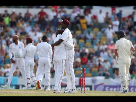 West Indies captain Jason Holder embraces a teammate at the end of day four of the first cricket Test match at the Kensington Oval in Bridgetown, Barbados, on Saturday, January 26, 2019. West Indies won by 381 runs. 