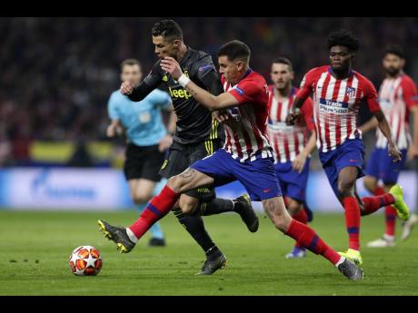ap
Atlético  Madrid defender Santiago Arias (right) puts a tackle in on Juventus forward Cristiano Ronaldo during their UEFA Champions League round of 16 first-leg match at the Wanda Metropolitano Stadium in Madrid, Spain, yesterday.