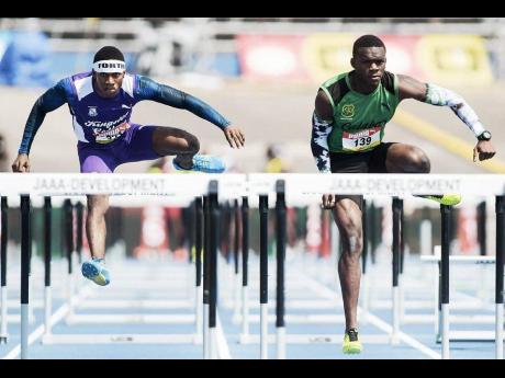 
Wayne Pinnock (left) of KC  and Orlando Bennett of Calabar High in the preliminary round of the Class One boys’ 110m hurdles at the 2018 ISSA/GraceKennedy Boys and Girls’ Championships.