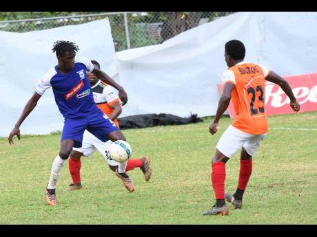 
Dwyane Foster (left) of Reno and Nickoy Christian of Dunbeholden vie for the ball during a Red Stripe Premier League match between Dunbeholden and  Reno yesterday.