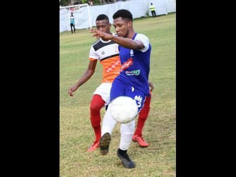 Donavan Brown (right) of Reno and Narado Brown of Dunbeholden go for the ball during a Red Stripe Premier League match between Dunbeholden and Reno yesterday at the Royal Lakes Sports Complex, in St Catherine.