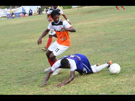 
Shevan James (left) of Dunbeholden and Reno’s  Renorio Downswell battle for the ball during the Red Stripe Premier League match between Dunbeholden and FC Reno  at  Royal Lakes Sports Complex on Sunday, March 10.
