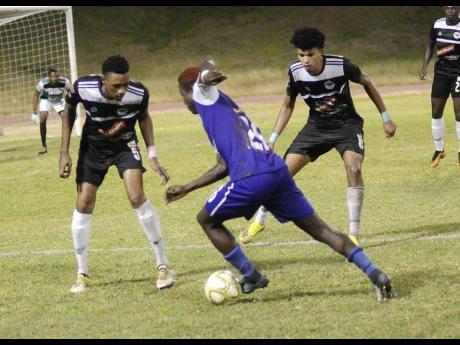
FC Reno’s Fancy-Hue Stewart (centre) drives forward while being closely marked by Cavalier’s Jamoy Topey (left) and his teammate Leonardo Rankine during their Red Stripe Premier League match at the Stadium East field earlier this season. FC Reno was relegated from the Red Stripe Premier League yesterday after going down 3-2 to Mount Pleasant FA. 