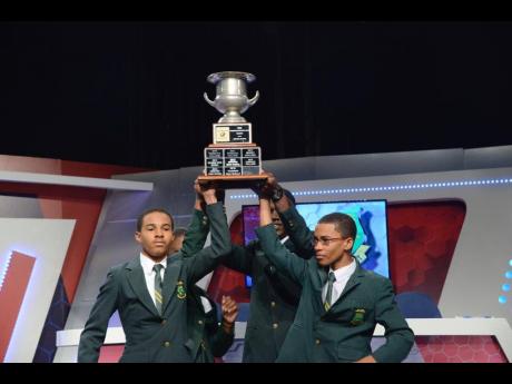 From left: St Jago High’s Joel Henriques, Abigail Barnes (partially hidden), Leroy Casanova, and Chanarie Lindsay celebrate with the 2019 School’s Challenge Quiz Trophy after defeating Kingston College in the final. 