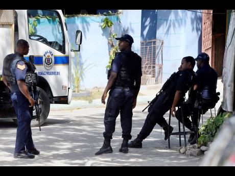 Police at the scene of a shooting in August Town, St Andrew, yesterday. 