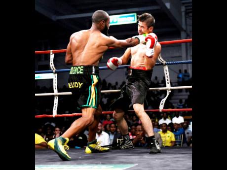 Sakima ‘Mr Smooth’ Mullings (left) lands a hard right on Alejandro Herrera during a boxing match at the National Indoor Sports Centre, in Kingston, on Wednesday, July 25, 2018.