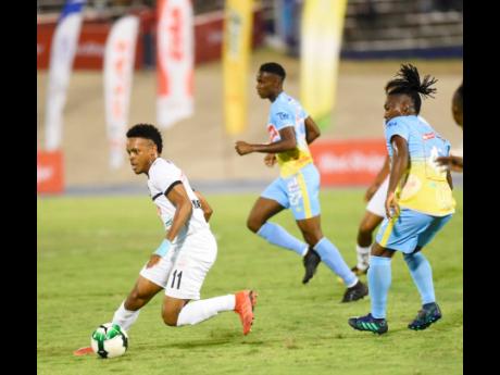 Cavalier FC’s Alex Marshall (left) on the offensive against Waterhouse’s FC’s Keammar Daley (right) during their first leg Red Stripe Premier League semi-final game at the National Stadium on Monday, April 8. Waterhouse’s Andre Leslie can also be seen tracking back in the background.