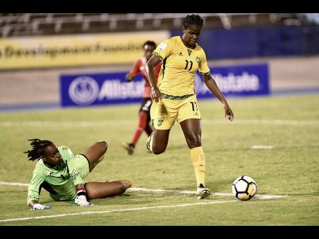 Jamaica’s Khadija Shaw (right) attempts to go around Trinidad and Tobago goalkeeper Kimika Forbes during a CONCACAF Caribbean Women’s Championships match at the National Stadium.