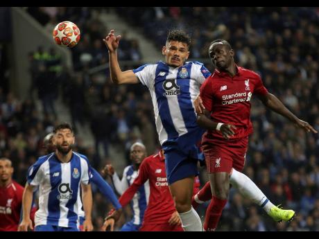 Liverpool’s Sadio Mane (right) jumps for the ball with Porto forward Francisco Soares during their second leg UEFA Champions League quarter-final match at Estadio Dragao in Porto, Portugal, yesterday.