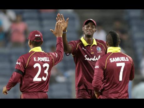 Windies captain Jason Holder (centre) celebrating with Keiron Powell (left) and Marlon Samuels. 
