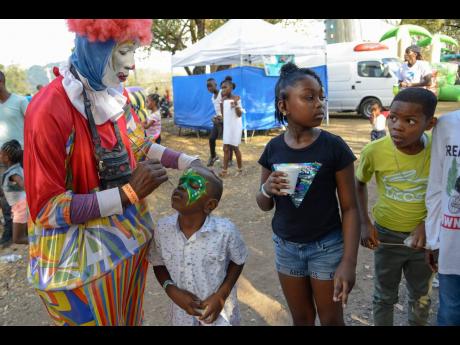  Jevaughn Jones gets his face painted as other children look on and wait their turn at Funfest.