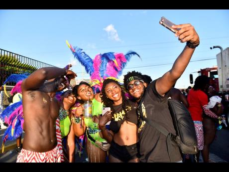 Xaymaca revellers (from left) Jevon Williams, Denille Ashwood, Jamila Samuels, Diamarei Bonner and Shaquiel Brooks take a group photo during yesterday’s Road March.