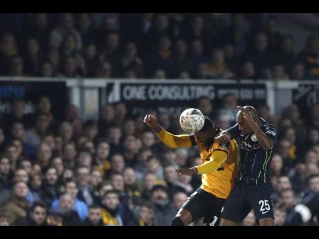 Newport County’s Jamille Matt (left) beats Manchester City’s Fernandinho to a header during their Emirates FA Cup fifth-round match at Rodney Parade in Newport, Wales on Saturday, February 16, 2019.