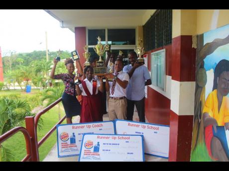 Members of the Maggotty High School debating team show off their prizes.