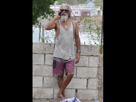 Billy Wilmot speaks on his phone after fire destroyed his home.