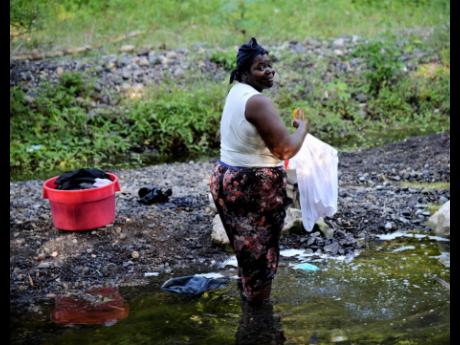 Credit: Ian Allen Julienne Burrell doing her weekly laundry in the Lucky Valley river near Rock River in Clarendon.
