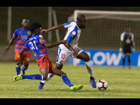 Javon East (right) of Portmore united is tackled by Judlin Piergile of AS Capoise during their FLOW Concacaf Caribbean Club Championhsip match at Stadium East in Kingston last night.
