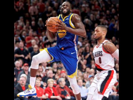 Golden State Warriors forward Draymond Green (left) prepares to shoot over Portland Trail Blazers guard Damian Lillard during the first half of Game 3 of the NBA basketball play-offs Western Conference finals on Saturday.