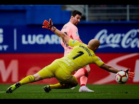 Barcelona’s Lionel Messi shoots to score in front of Eibar’s goalkeeper Marko Dmitrovic, during a Spanish La Liga match at the Ipurua stadium in Eibar, northern Spain, yesterday.