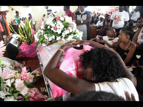 Crystal Service, Shante’s mother, clings to the casket as she grieves for her daughter.