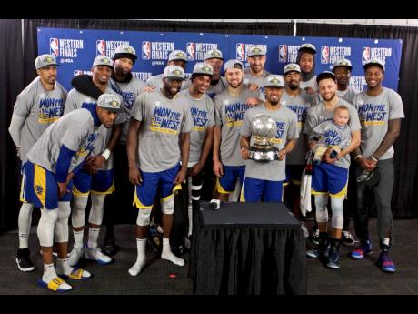 The Golden State Warriors players pose with the Western Conference Championship trophy after Game Four of the NBA basketball play-offs Western Conference finals against the Portland Trail Blazers on Monday.