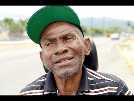 Credit: Ian Allen Brenton Orr, a wheelchair-bound man from Maxfield Avenue, travelling along Old Hope Road after one of his many visits to the University Hospital of the West Indies recently.