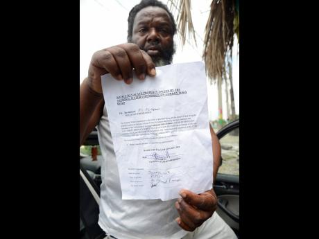 Courtney McEwan shows the eviction notice he and other persons received in January.