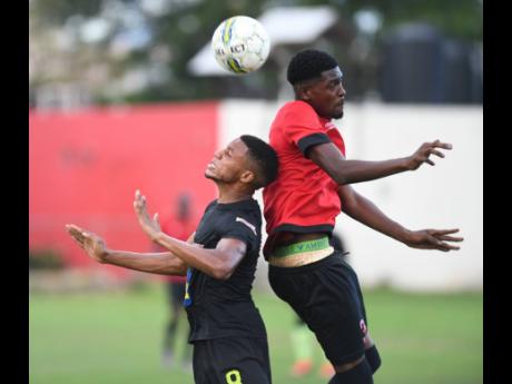 Credit: Ricardo Makyn Ackeem Stewart (left) of Molynes United goes up for a header with Lime Hall player Mickalie McKoy in the JFF Premier league playoff at the Constant Spring playfield on Sunday.
