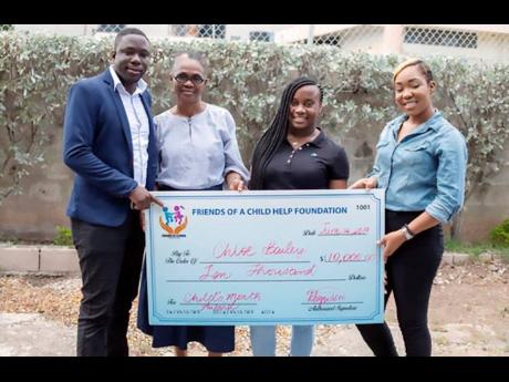 Founder of Help A Child Foundation, Jason Evans (left), presents a cheque to Chloe Bailey (second right), a recipient of the foundation’s outreach activities, while her grandmother Ida Hughes (second left), and Petagaye Ferguson, the foundation’s legal adviser, look on.
