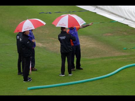 Umpires inspect the pitch after rain stopped play during the ICC World Cup cricket match between South Africa and the West Indies at the Ageas Bowl in Southampton yesterday.