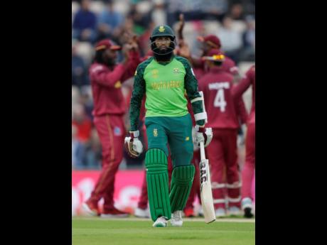 South Africa’s Hashim Amla leaves the pitch after he is caught by West Indies’ Chris Gayle off the bowling of West Indies’ Sheldon Cottrell.