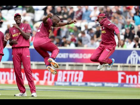 West Indies’ bowler André Russel (second from right) celebrates with Darren Bravo taking the wicket of Pakistan’s Haris Sohail as West Indies’ captain, Jason Holder (left) smiles during a Cricket World Cup match at Trent Bridge cricket ground in Nottingham, England, last Friday.