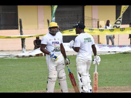 Petersville and Jamaica Scorpion’s all-rounder Derval Green with his batting partner  Howard Jamieson in a SDC/Wray and Nephew T20 Community Cricket match at the Seaview Complex in Whitehouse, Westmoreland.