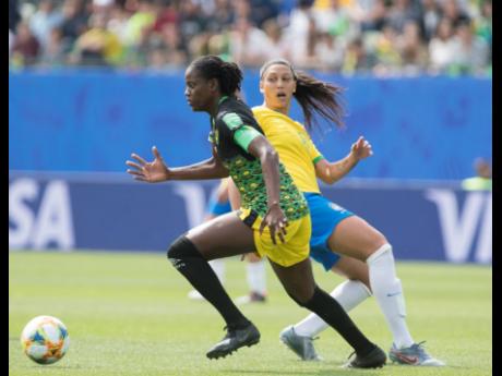 Reggae Girlz team captain Konya Plummer (left) dribbles by Brazil’s Beatriz Zaneratto Joao in the Jamaica’s opening game of the 2019 FIFA Women’s World Cup against Brazil on June 9, 2019.