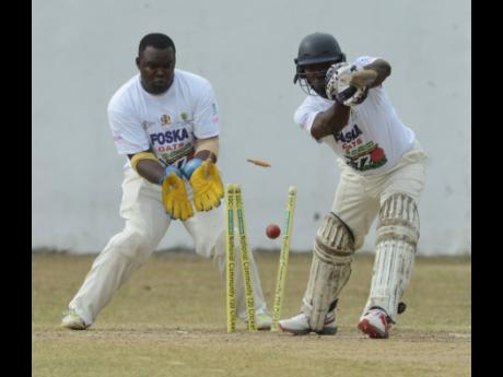 Kenroy Henriques (right) from Yallahs is bowled by Ryan Brown (out of picture), while wicketkeeper Domain Taylor looks on during the Social Development Corporation (SDC) T20 Community Cricket held at the Goodyear Oval in Springfield, St. Thomas, on Sunday, May 26, 2019.