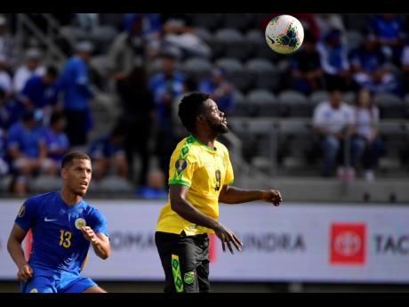 Credit: Mark J. Terrill Jamaica midfielder Ricardo Morris, right, heads the ball next to Curacao defender Jurien Gaari during the first half of a CONCACAF Gold Cupr match yesterday.