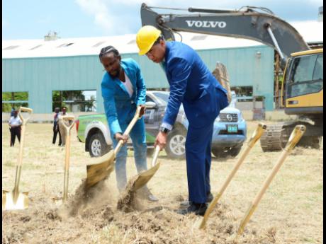 Prime Minister Andrew Holness (right) and St Thomas-born dancehall artiste Popcaan, given name Andrae Hugh Sutherland, break ground for the Morant Bay Urban Centre yesterday, on the grounds of the old Goodyear Factory yesterday.