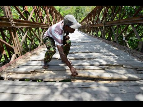 A resident of Ramble shows how the bridge has deteriorated because of lack of maintainance.