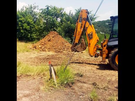 The back hoe begins to dig the area for the tanks.